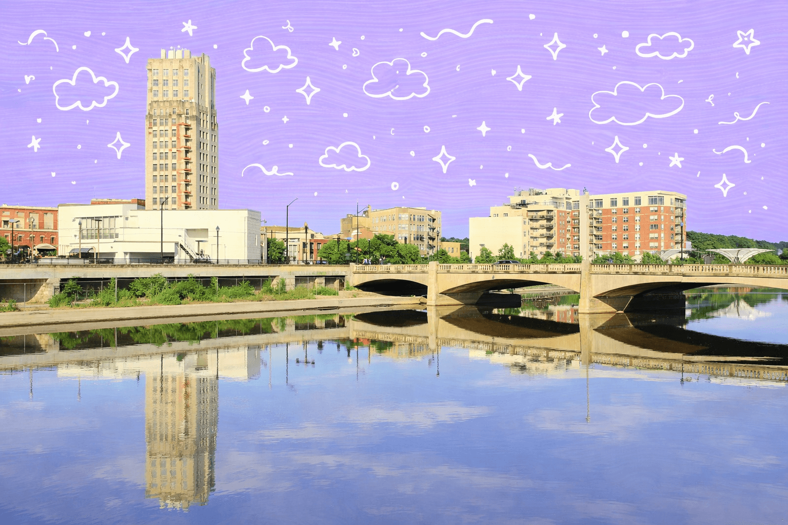 Scenic view of Elgin, IL, showcasing tall buildings and a bridge reflected in the river.