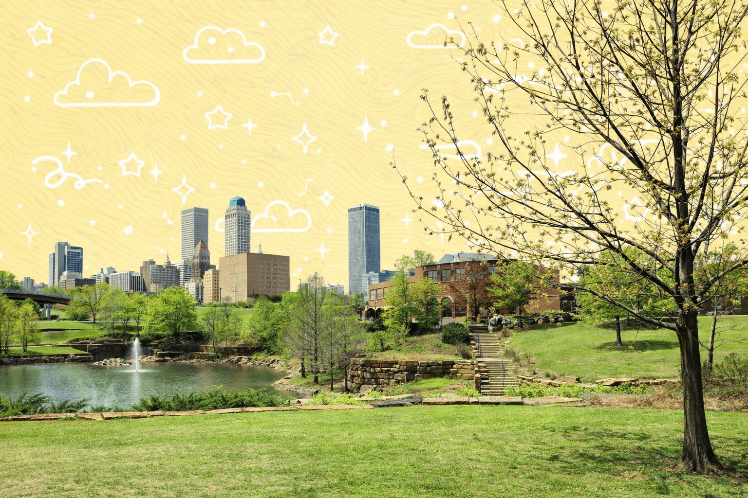View of Tulsa, OK skyline from a park with a pond and trees in the foreground on a sunny day.