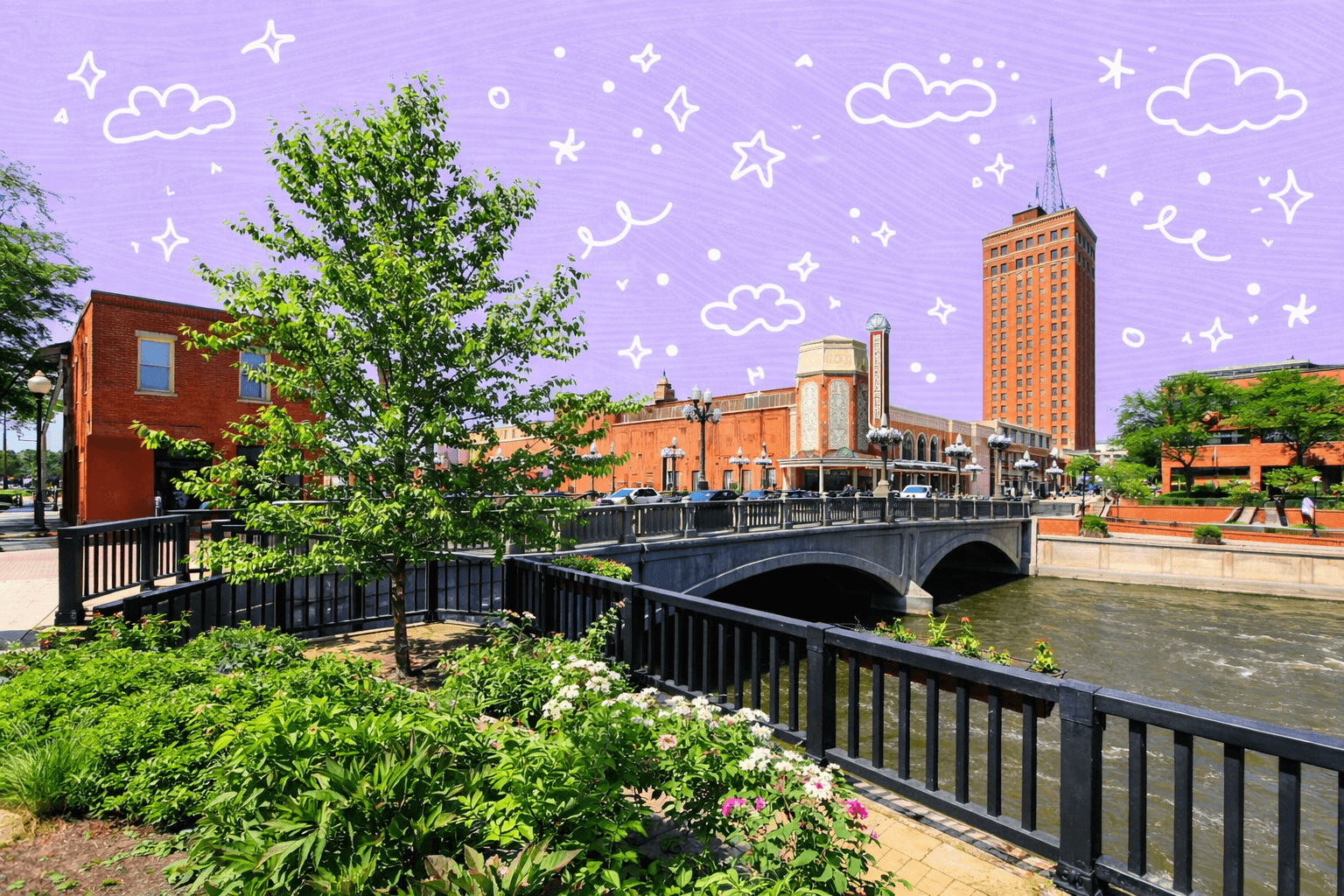 Downtown Aurora, IL with a bridge over the Fox River and historic buildings under a clear blue sky.