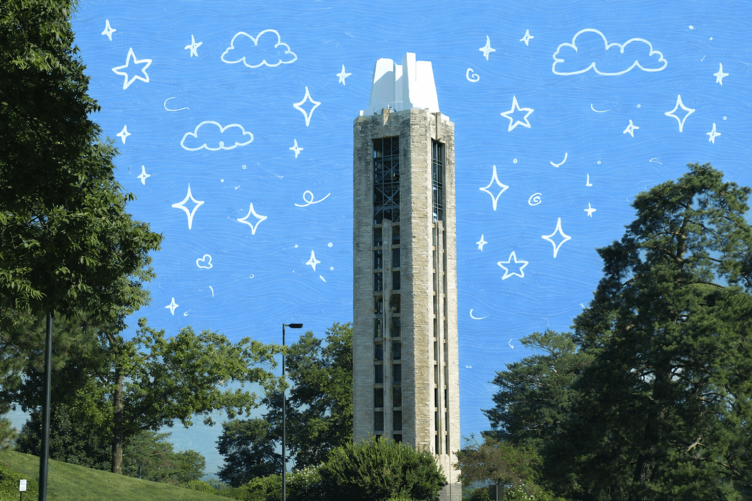 Campanile tower rising above trees on the University of Kansas campus in Lawrence, Kansas on a sunny day.