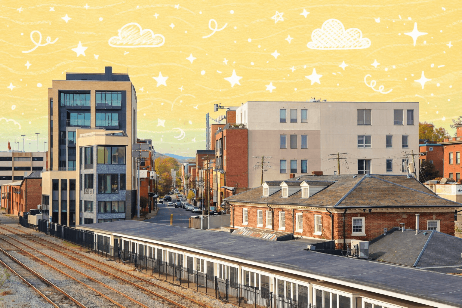 View of a vibrant neighborhood in Charlottesville, VA with train tracks and modern buildings.