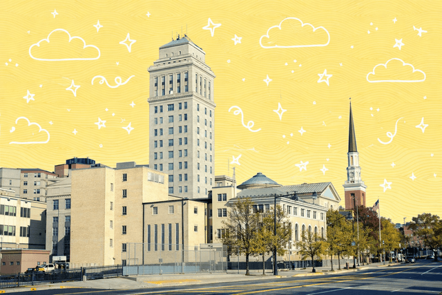 Skyline view of Elizabeth, NJ featuring historic buildings and a church spire under a clear blue sky.