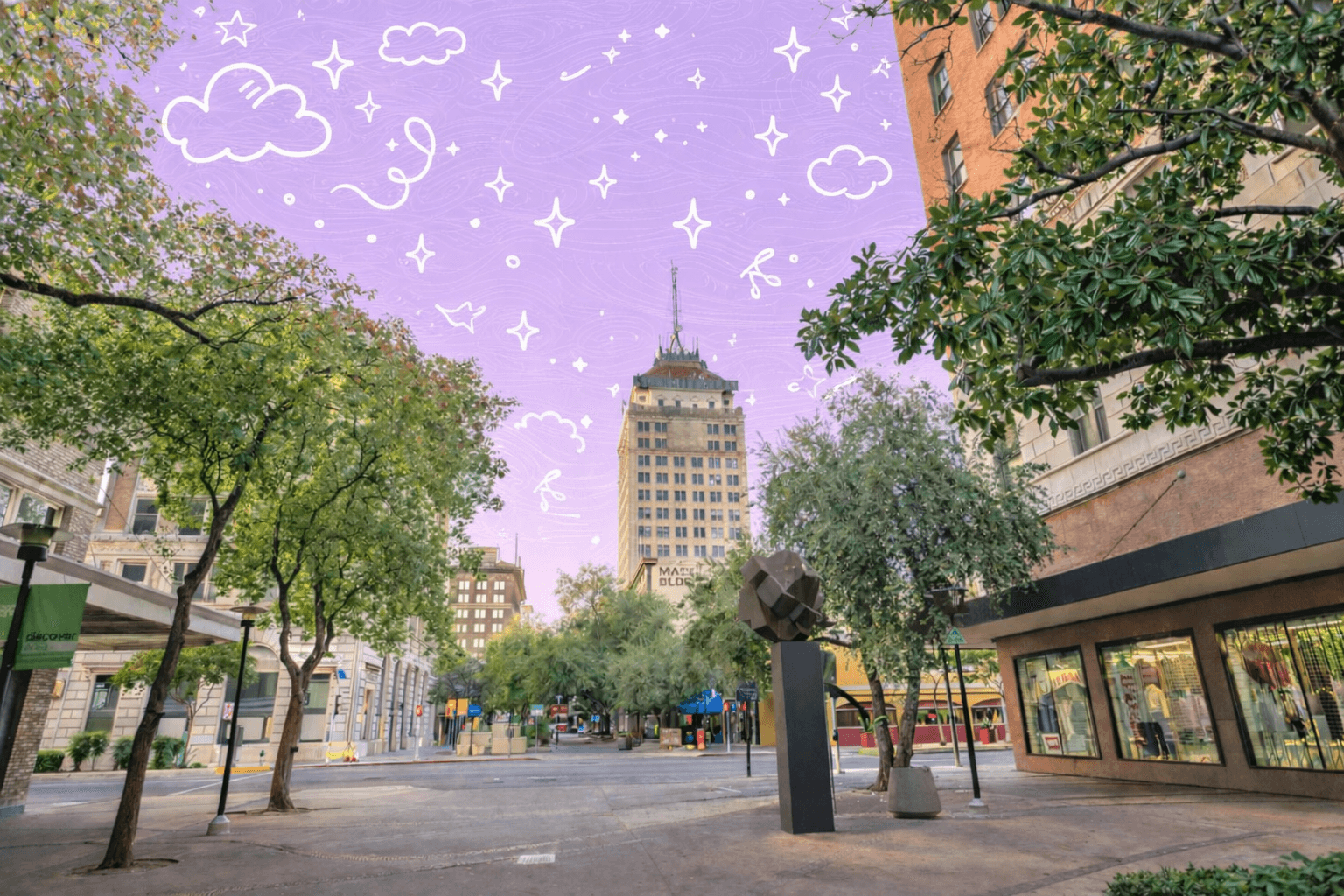 Downtown Fresno California street scene with historic buildings, trees, sculpture, and the Pacific Southwest Building rising above the city plaza