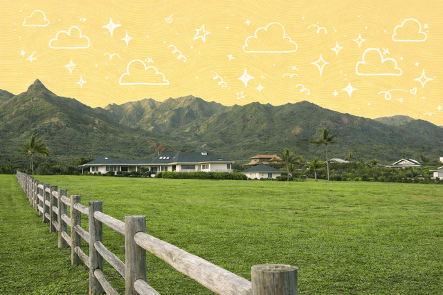 Scenic view of homes with lush green lawns and mountains in Kauai, Hawaii.