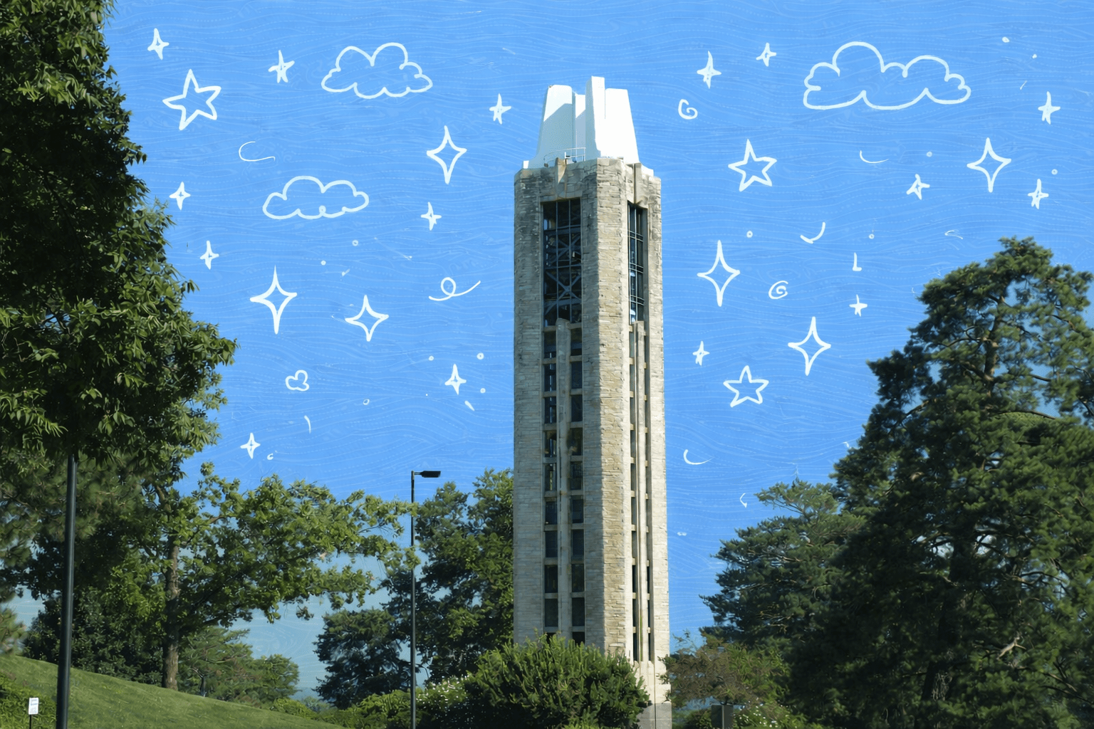 Campanile tower rising above trees on the University of Kansas campus in Lawrence, Kansas on a sunny day.