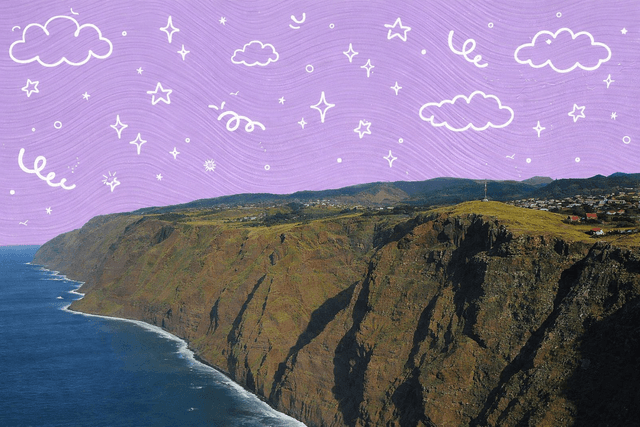 Dramatic coastline cliffs of Molokai, Hawaii against a cloudy blue sky.