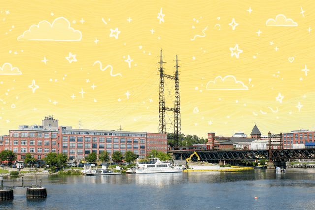 Waterfront scene in Norwalk, CT with buildings, boats, and a blue sky.