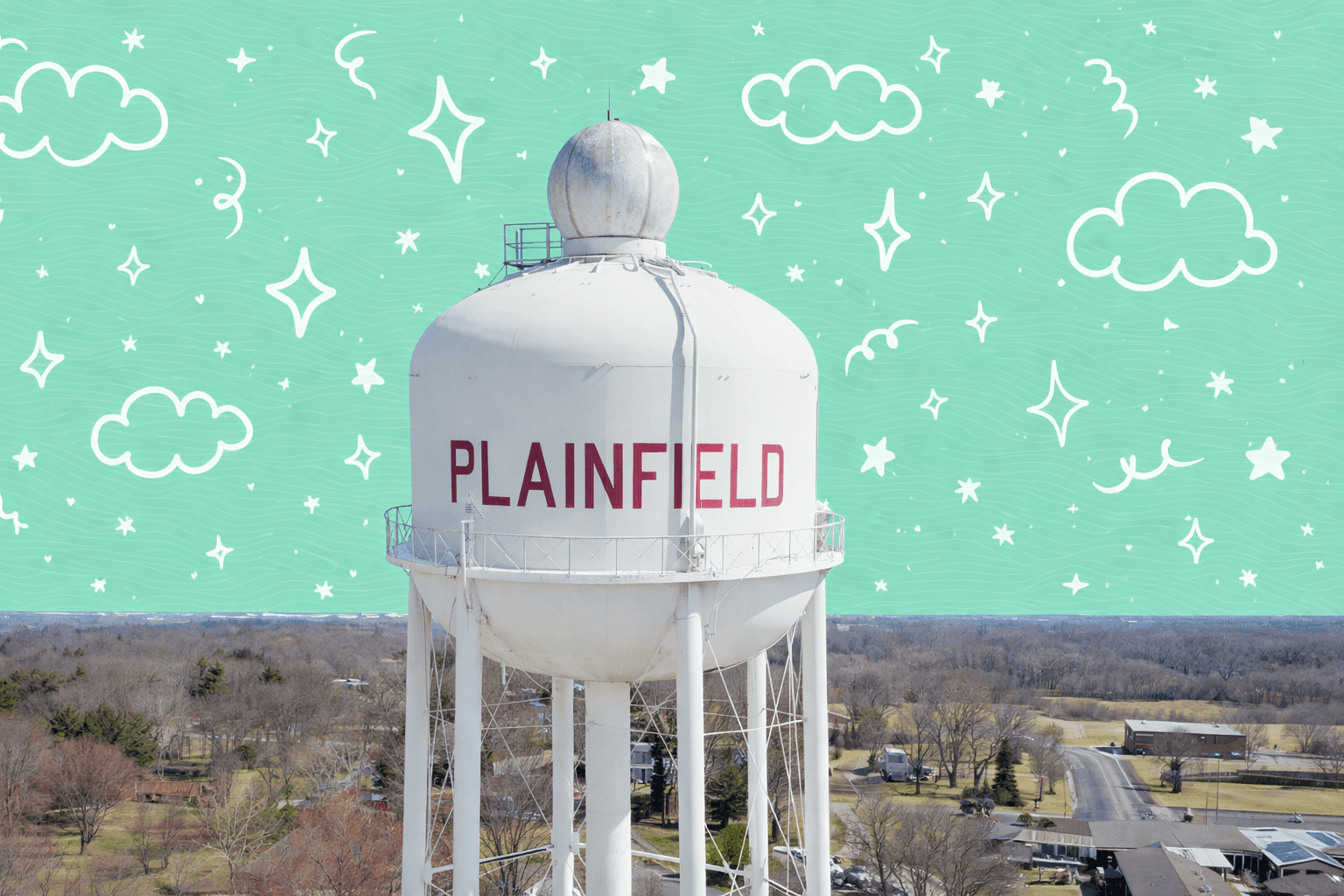 Aerial view of the Plainfield, IL water tower amid suburban homes and trees under a clear blue sky.