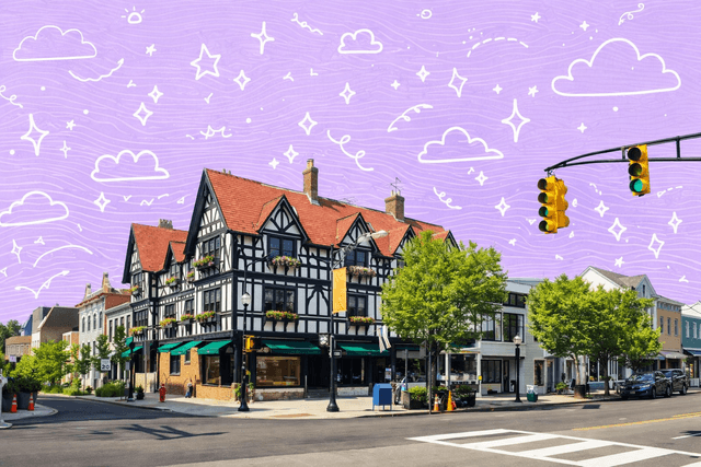 Charming Tudor-style building in Princeton, NJ under a clear blue sky, with traffic lights and surrounding greenery.