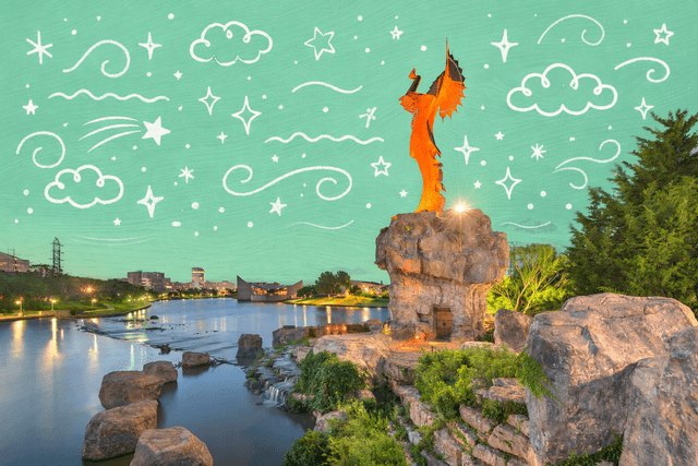 Keeper of the Plains statue illuminated at sunset along the Arkansas River in Wichita Kansas with city skyline and riverfront landscape.